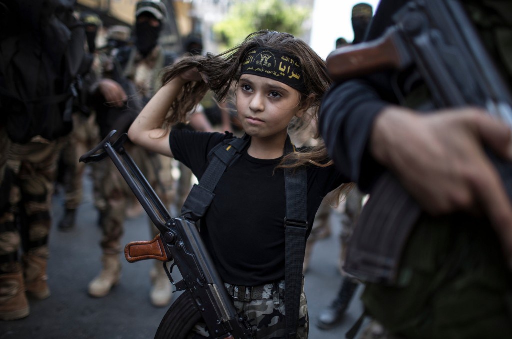 A Palestinian girl carries a Kalashnikov rifle during a victory parade for Islamic Jihad in Gaza City. (Photo credit: Wissam Nassar, New York Times)